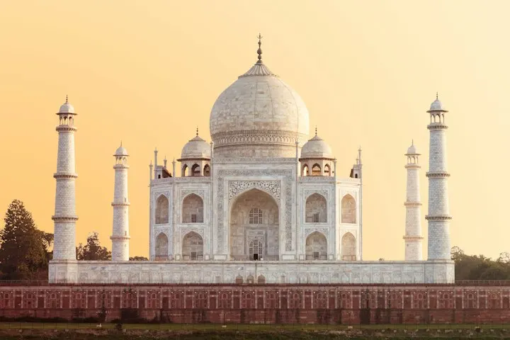 The Taj Mahal in Agra under a warm golden hour sky Taj Mahal Sunset: Agra holiday packages by OYG Holidays