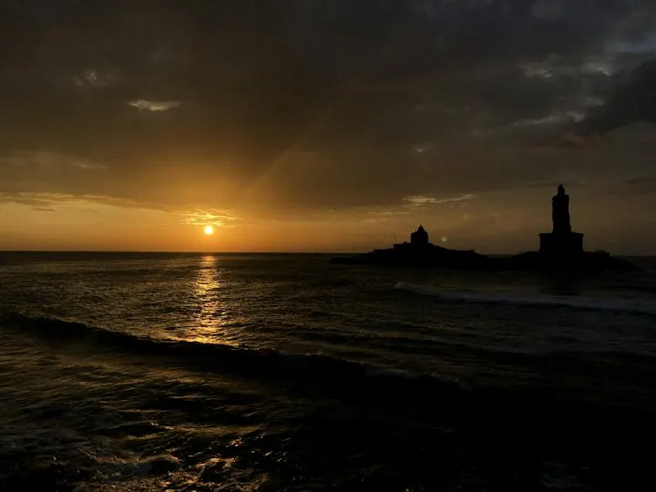 Silhouette of building on island during sunset: Kanyakumari holiday packages by OYG Holidays
