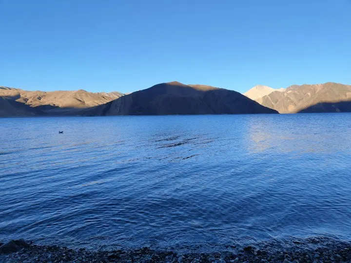A body of water with mountains in the background Pangong lake, where the Earth meets heaven: Ladakh holiday packages by OYG Holidays